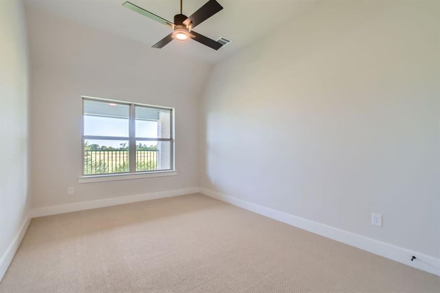 Spare room featuring light colored carpet, a ceiling fan, and vaulted ceiling Spare room featuring light colored carpet, a ceiling fan, and vaulted ceiling