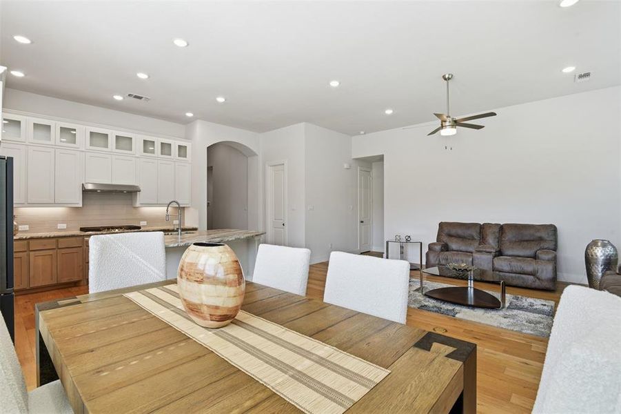 Kitchen and living area featuring wood-finish flooring, recessed lighting, and a ceiling fan Kitchen and living area featuring wood-finish flooring, recessed lighting, and a ceiling fan