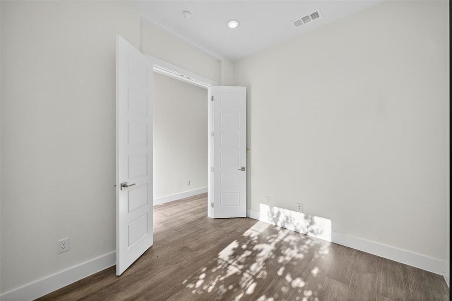 Empty room featuring dark wood-type flooring and baseboards Empty room featuring dark wood-type flooring and baseboards