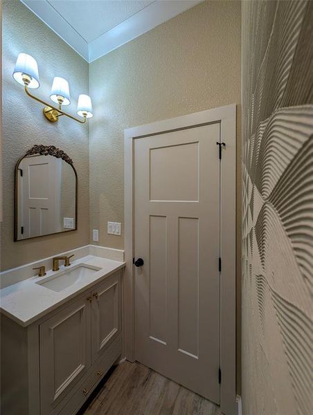 Bathroom featuring vanity, a textured wall, and light wood-type flooring