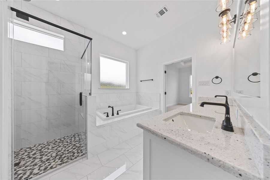 Bathroom featuring vanity, a bath, a stall shower, recessed lighting, and marble look tiles