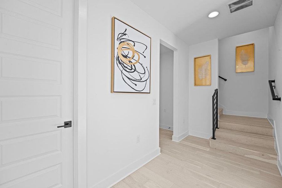 Hall with stairway, light wood-style floors, and recessed lighting