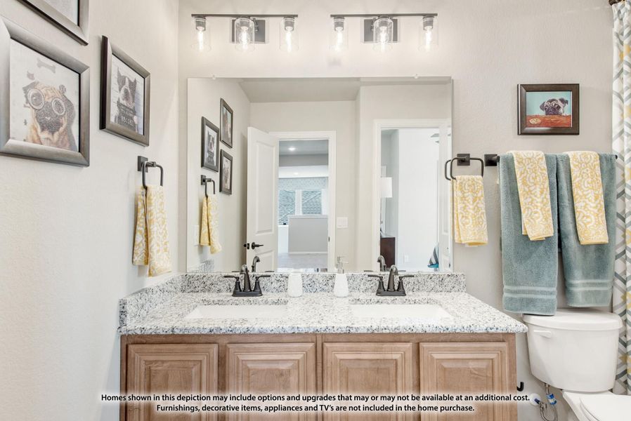 Bathroom with double sink vanity, granite countertop, wood cabinets, and large mirror with overhead lighting Bathroom with double sink vanity, granite countertop, wood cabinets, and large mirror with overhead lighting