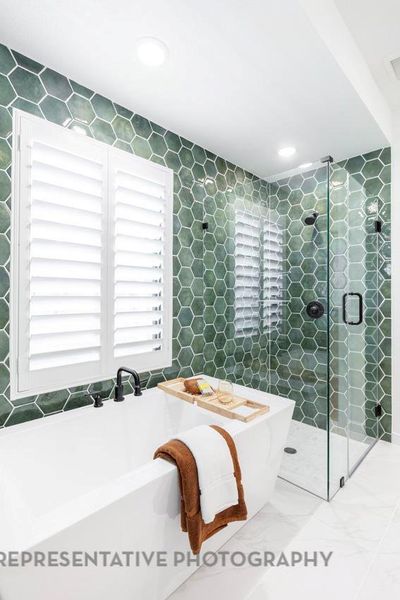 Bathroom featuring a soaking tub, a stall shower, tile walls, and recessed lighting Bathroom featuring a soaking tub, a stall shower, tile walls, and recessed lighting