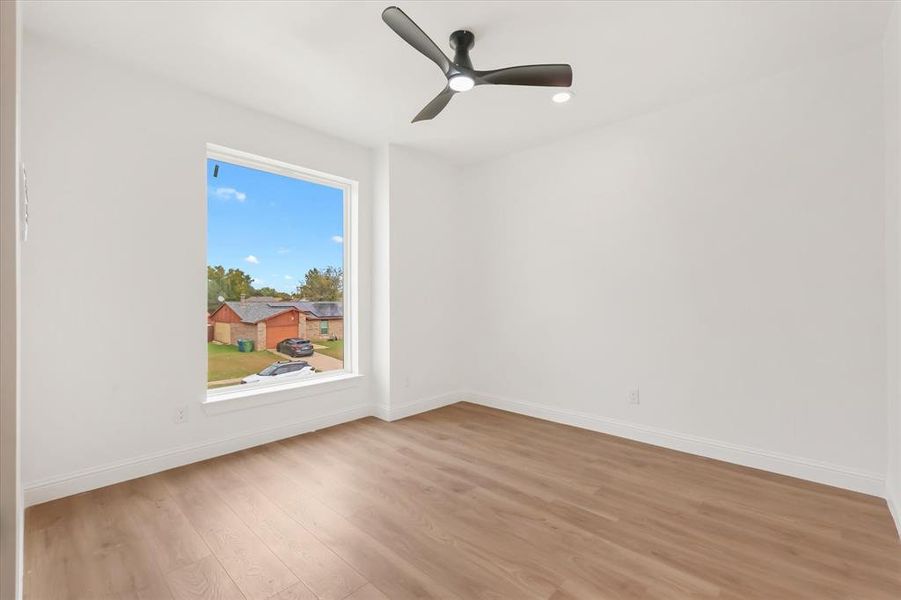 Empty room featuring light wood-type flooring and a ceiling fan Empty room featuring light wood-type flooring and a ceiling fan