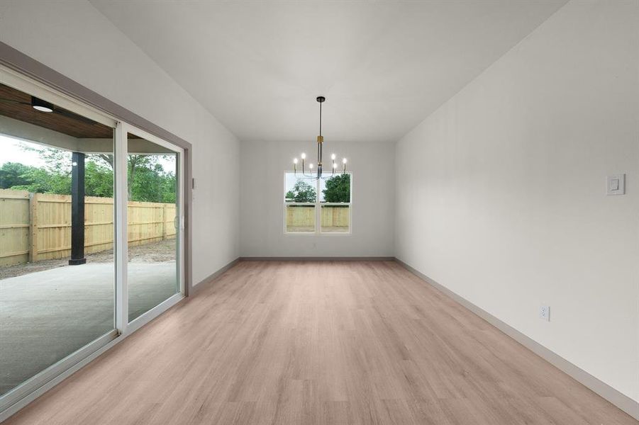 Unfurnished dining area featuring light wood-type flooring, baseboards, plenty of natural light, and a notable chandelier