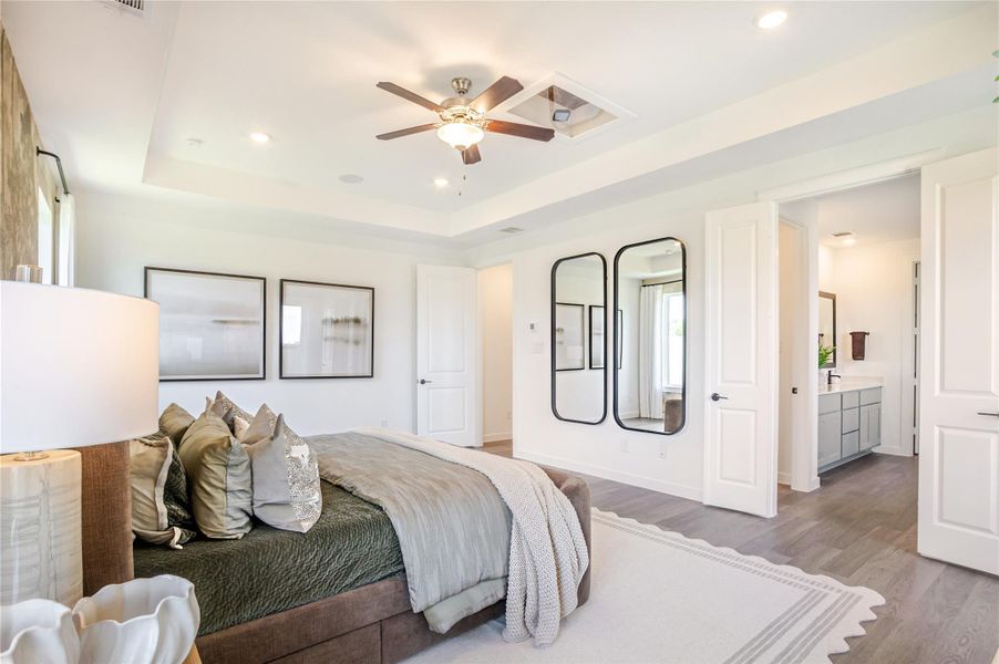 The Primary bedroom is bright, modern with a ceiling fan, elegant decor, and ample natural light. It features a cozy bed with plush pillows, wall art, and a large ensuite bathroom. The room has a spacious feel with light wood flooring and contemporary accents. The Primary bedroom is bright, modern with a ceiling fan, elegant decor, and ample natural light. It features a cozy bed with plush pillows, wall art, and a large ensuite bathroom. The room has a spacious feel with light wood flooring and contemporary accents.