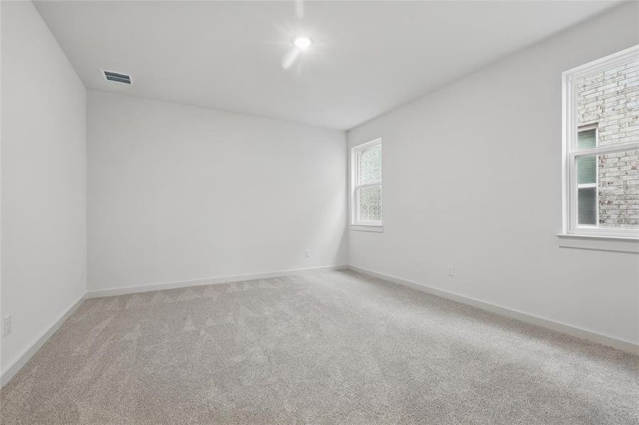 Spare room with light colored carpet, visible vents, and baseboards Spare room with light colored carpet, visible vents, and baseboards