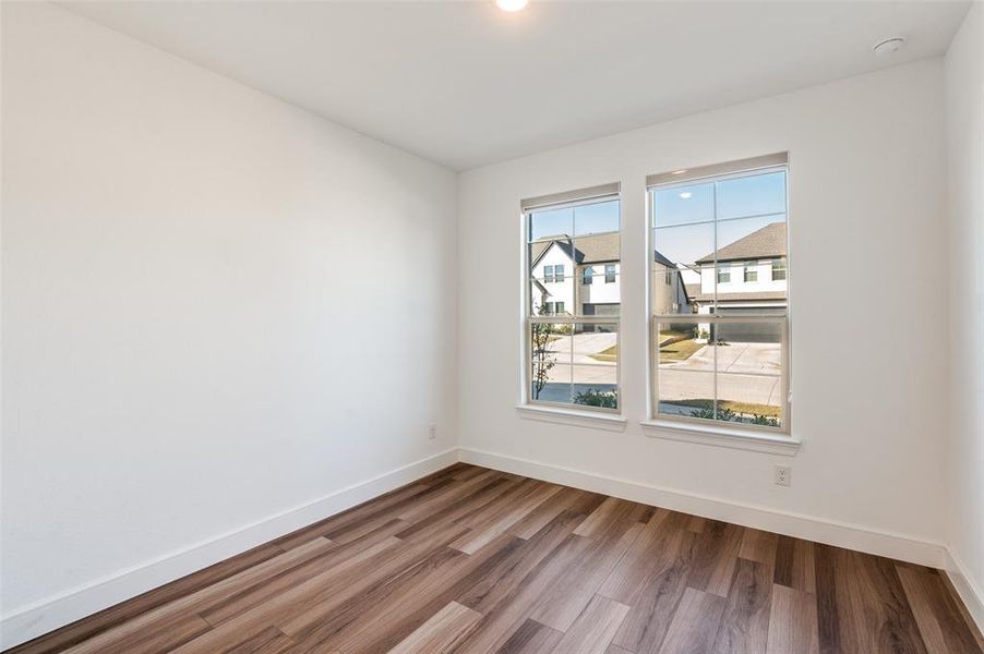 Downstairs bedroom with wood finished floors and baseboards Downstairs bedroom with wood finished floors and baseboards