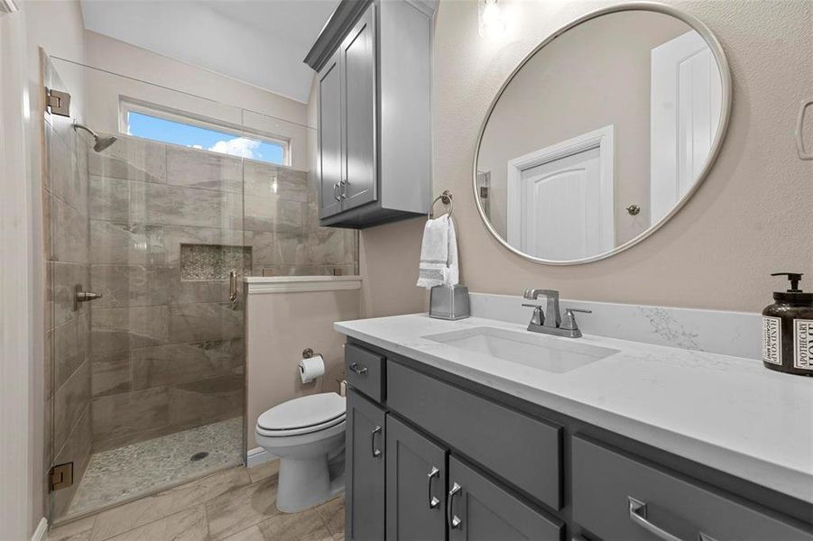 Bathroom featuring vanity, toilet, and an enclosed shower