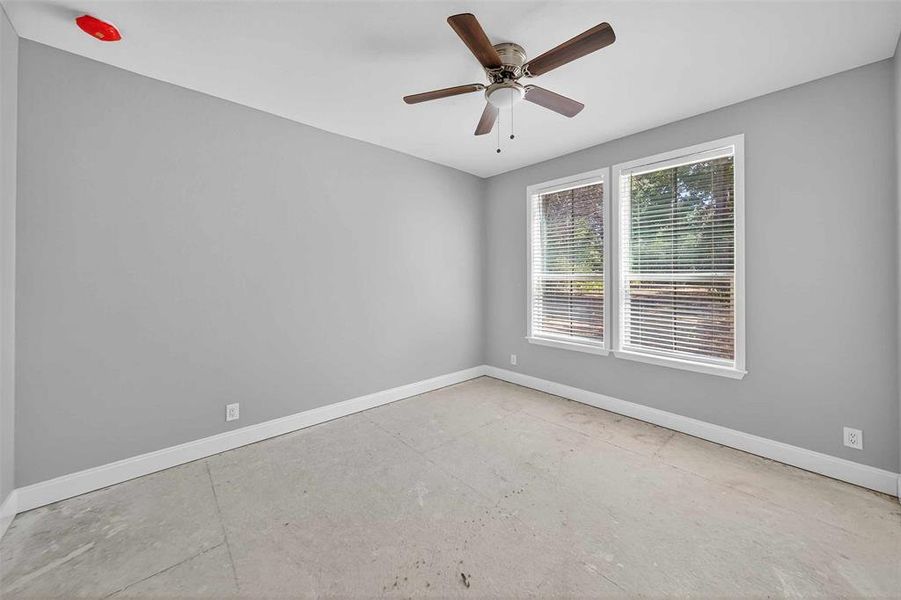 Unfurnished room with a ceiling fan and concrete flooring