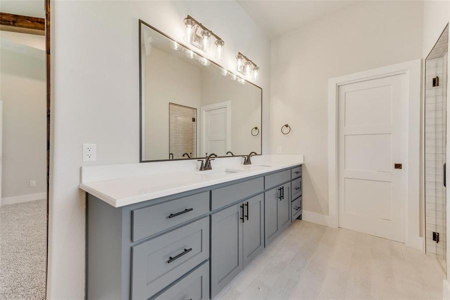 Bathroom with hardwood / wood-style floors, vanity, and tiled shower