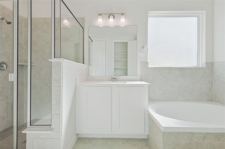 Bathroom featuring vanity, separate shower and tub, and tile patterned flooring