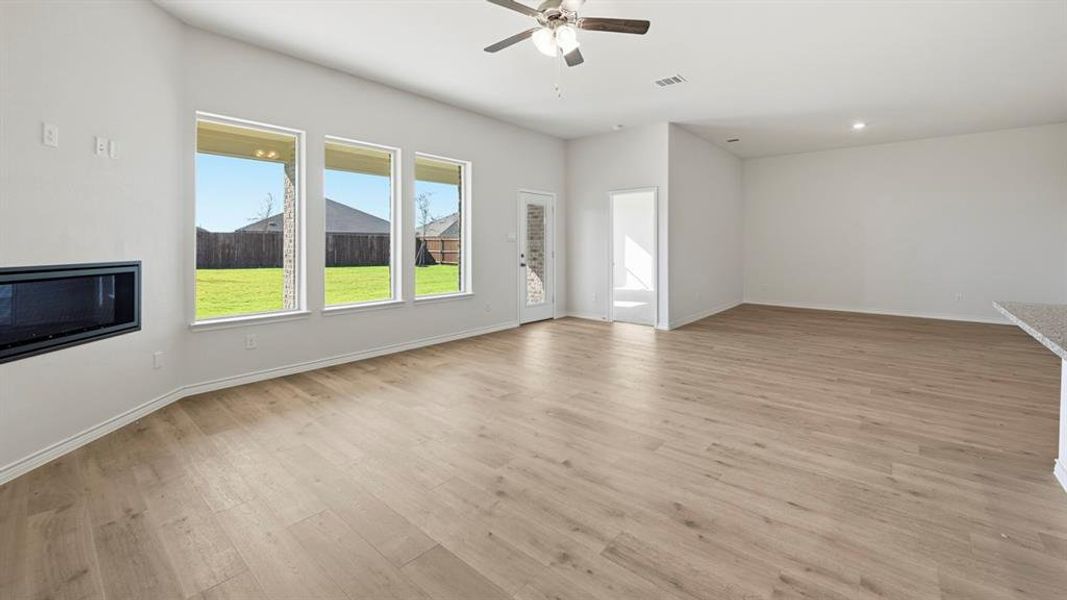 Unfurnished living room featuring light wood-style flooring, ceiling fan, and recessed lighting