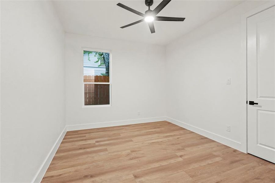 Spare room featuring light wood finished floors and a ceiling fan Spare room featuring light wood finished floors and a ceiling fan