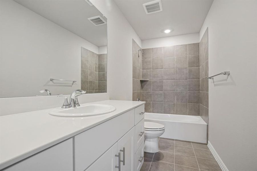 Full bath with vanity, washtub / shower combination, and light tile patterned flooring