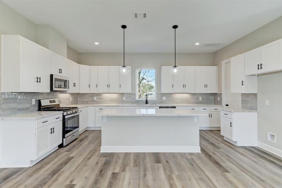 Light & Bright Kitchen with plenty cabinet & counter space, quartz counters, and spacious Island