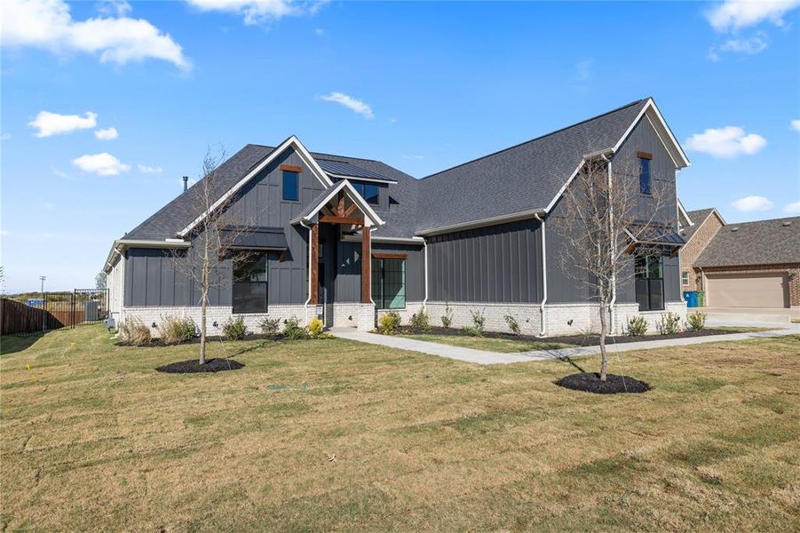 Modern inspired farmhouse with board and batten siding, brick siding, and roof with shingles Modern inspired farmhouse with board and batten siding, brick siding, and roof with shingles