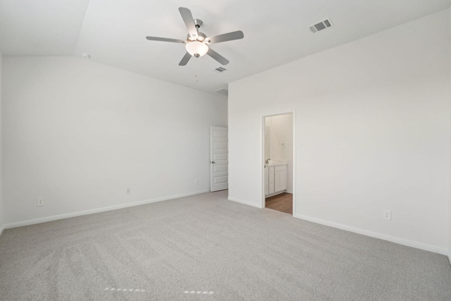 Unfurnished bedroom with carpet, ceiling fan, vaulted ceiling, and ensuite bathroom