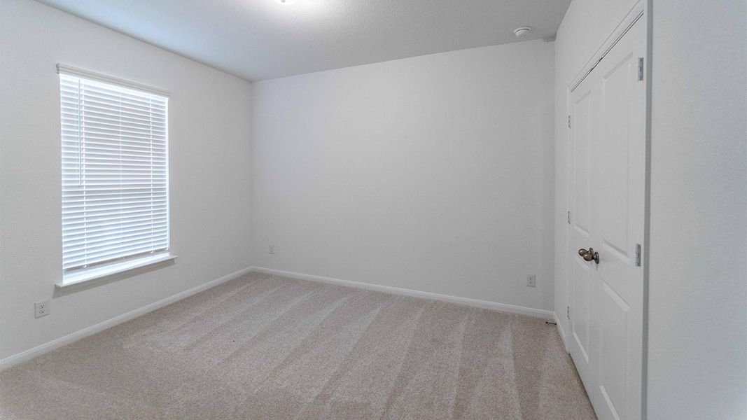 Unfurnished bedroom with light carpet and a closet