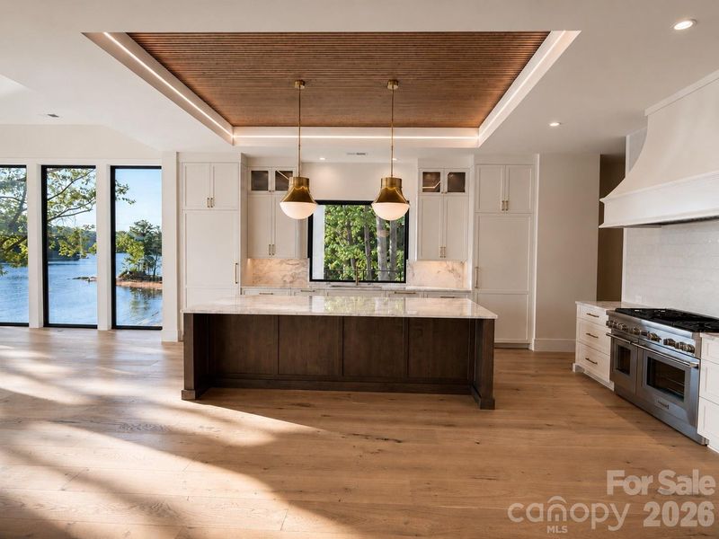 Stunning kitchen features 48" gas range, waterfall marble countertops, wood detailed ceiling and expansive scullery with a built-in coffee station, dishwasher, and ample storage/pantry space Stunning kitchen features 48" gas range, waterfall marble countertops, wood detailed ceiling and expansive scullery with a built-in coffee station, dishwasher, and ample storage/pantry space