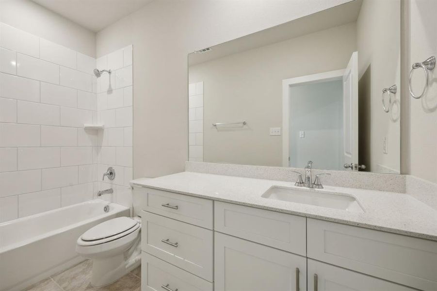 Bathroom featuring, toilet,  shower combination, tile patterned flooring, and vanity