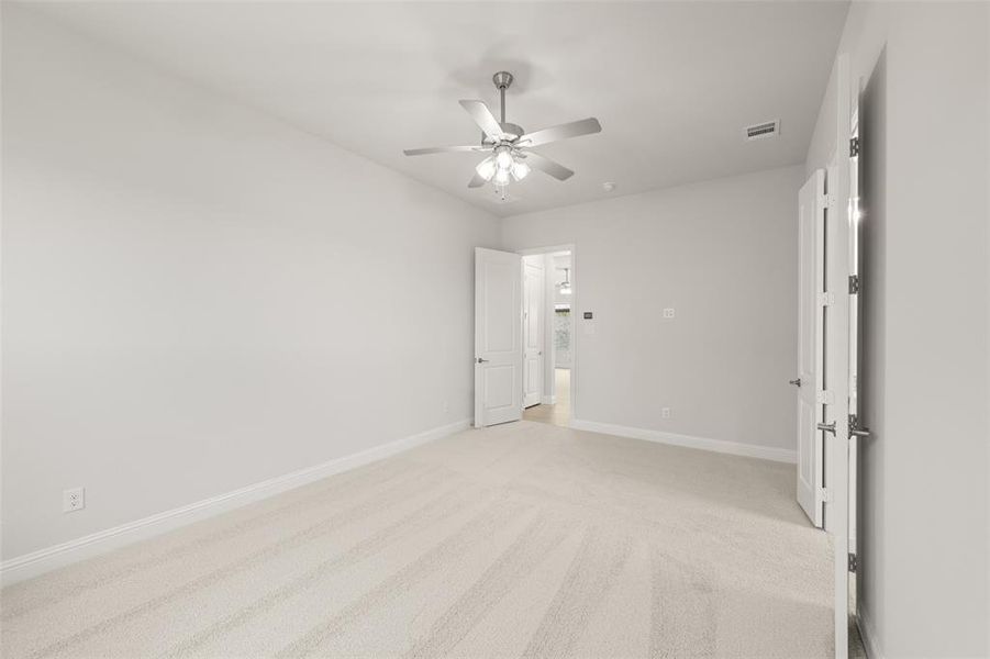 Unfurnished bedroom with light colored carpet and ceiling fan Unfurnished bedroom with light colored carpet and ceiling fan
