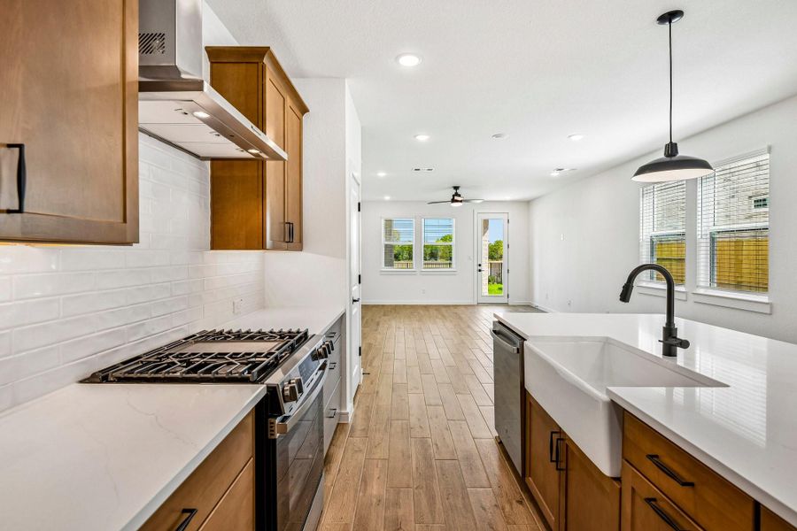 Stylish kitchen with light stain cabinets and quartz counters