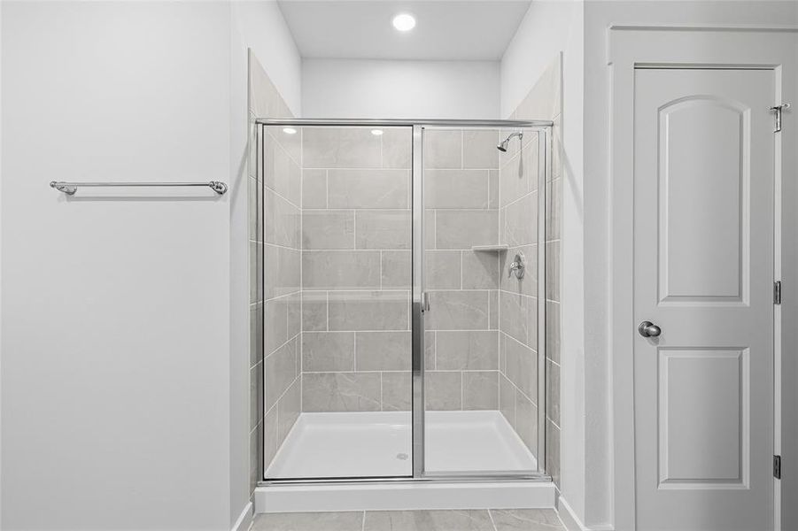 Bathroom featuring a shower stall and light tile patterned floors Bathroom featuring a shower stall and light tile patterned floors