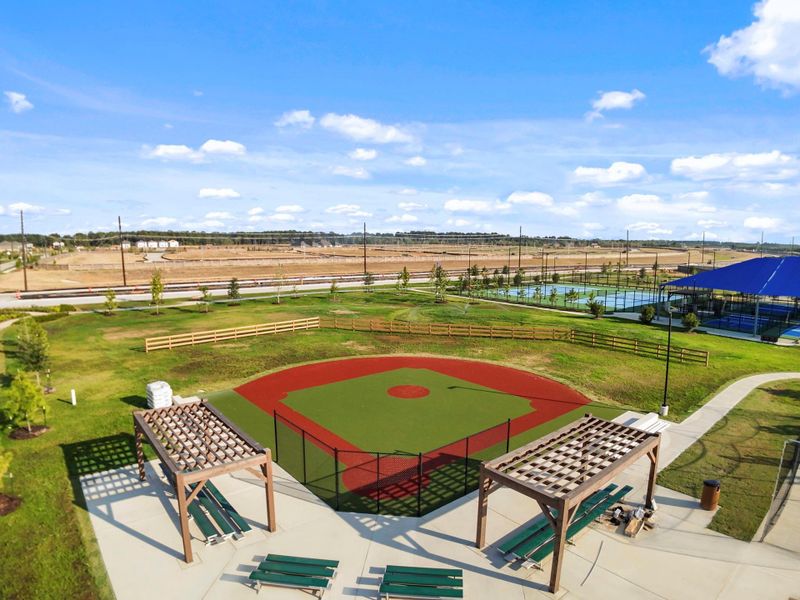 The community offers a beautiful outdoor recreation area complete with a baseball field and shaded seating, perfect for family outings or friendly games under the Texas sun.