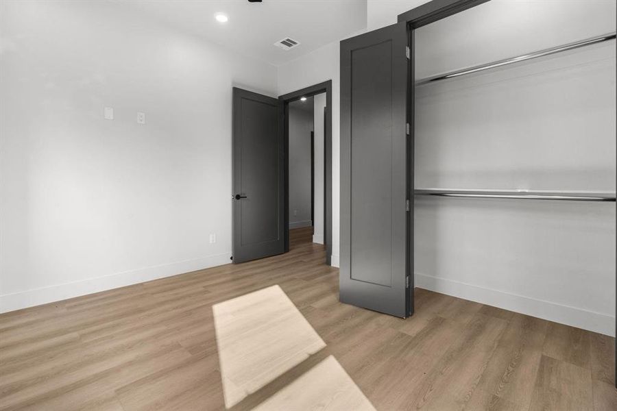 Unfurnished bedroom featuring light wood-style flooring, a closet, and recessed lighting