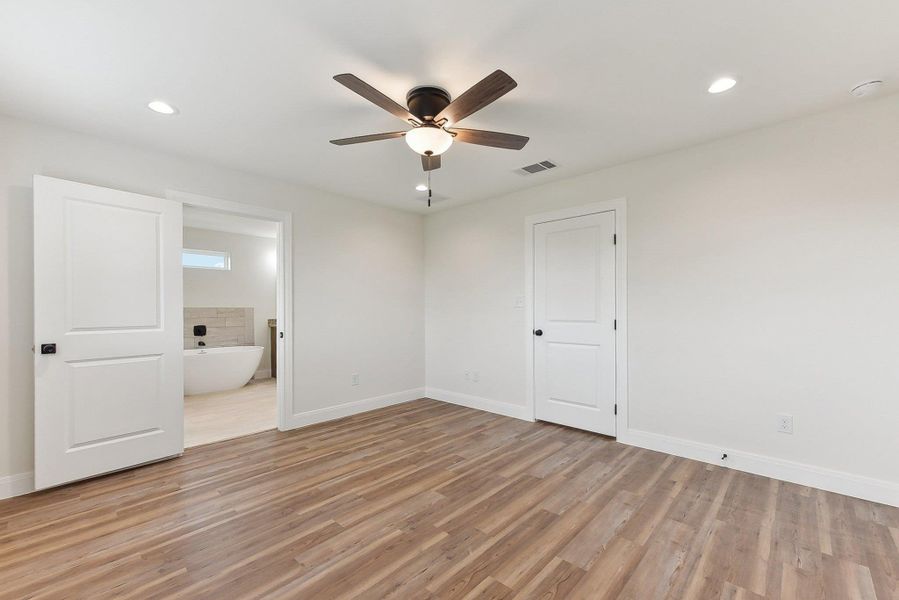 Primary Bedroom featuring light wood style floors, baseboards, visible vents, recessed lighting, and ceiling fan