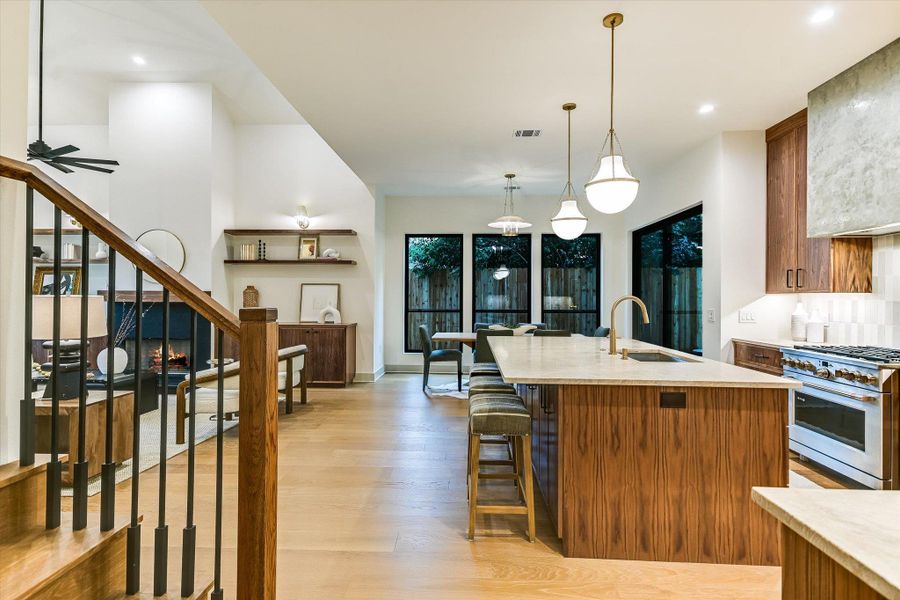 The living space flows to the gourmet kitchen, breakfast bar, and dining area, all bathed in warm natural lighting. The living space flows to the gourmet kitchen, breakfast bar, and dining area, all bathed in warm natural lighting.