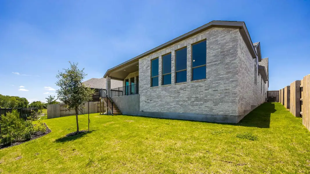 View of home's exterior with stairway, brick siding, and a fenced backyard View of home's exterior with stairway, brick siding, and a fenced backyard