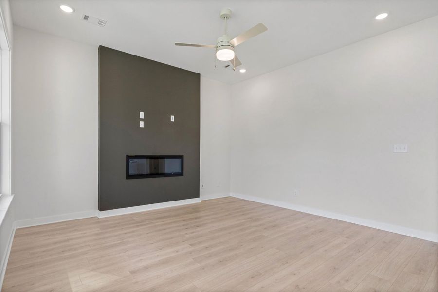 Recessed lighting, wood-finish flooring, ceiling fan, and a contemporary linear fireplace