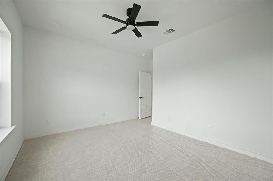 Unfurnished room with a ceiling fan and light colored carpet Unfurnished room with a ceiling fan and light colored carpet