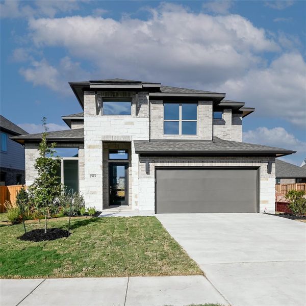 View of front of home featuring an attached garage, stone siding, brick siding, and concrete driveway View of front of home featuring an attached garage, stone siding, brick siding, and concrete driveway