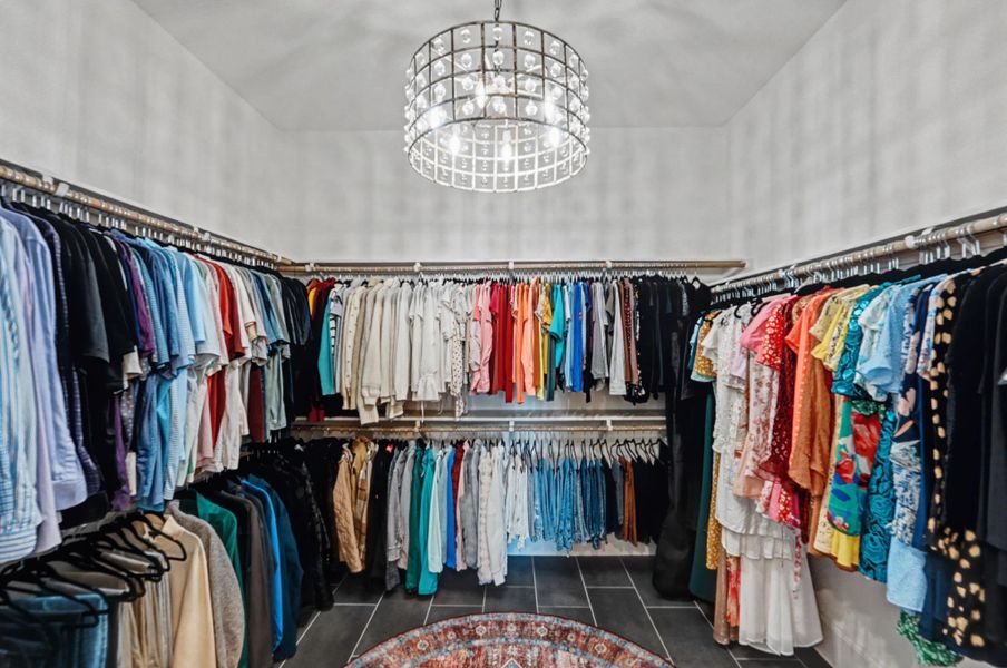 Large walk-in closet with extensive hanging space, built-in organization, and overhead lighting.
