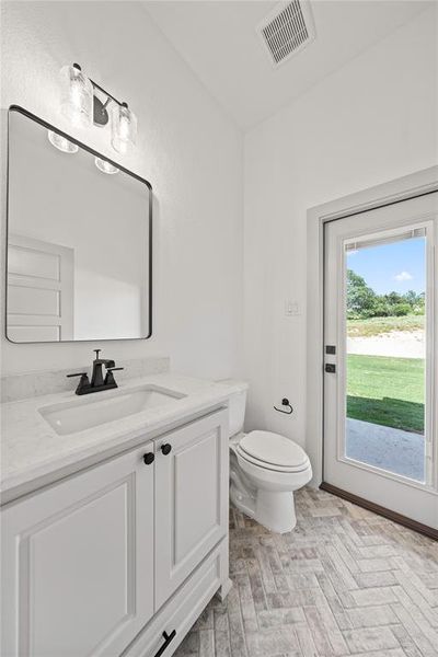 Half bathroom featuring vanity and toilet Half bathroom featuring vanity and toilet