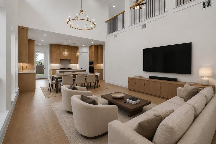 Open-concept living area with soaring ceilings and wood-finish flooring