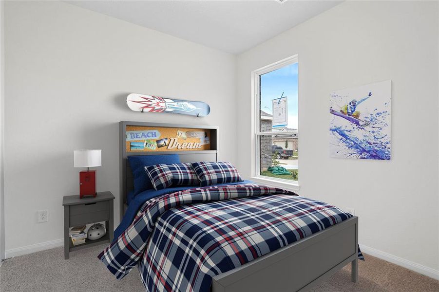 Secondary bedroom features plush carpet, custom paint, ample closet space, and a large window.