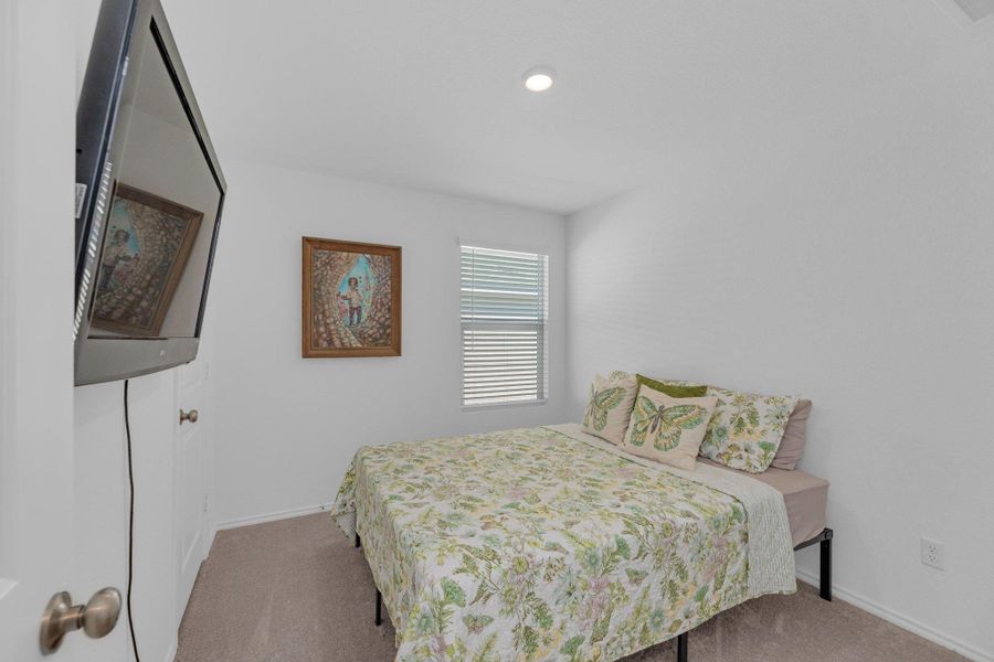 Bedroom featuring carpet and baseboards