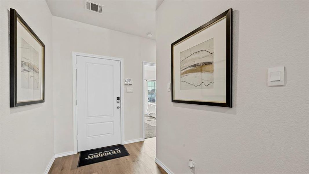 The property features light-colored walls, wood-style flooring, and a white entry door The property features light-colored walls, wood-style flooring, and a white entry door