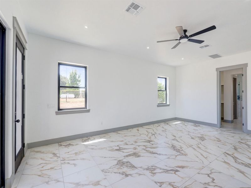 Polished stone-patterned tile flooring and clean lines define this versatile modern interior space.