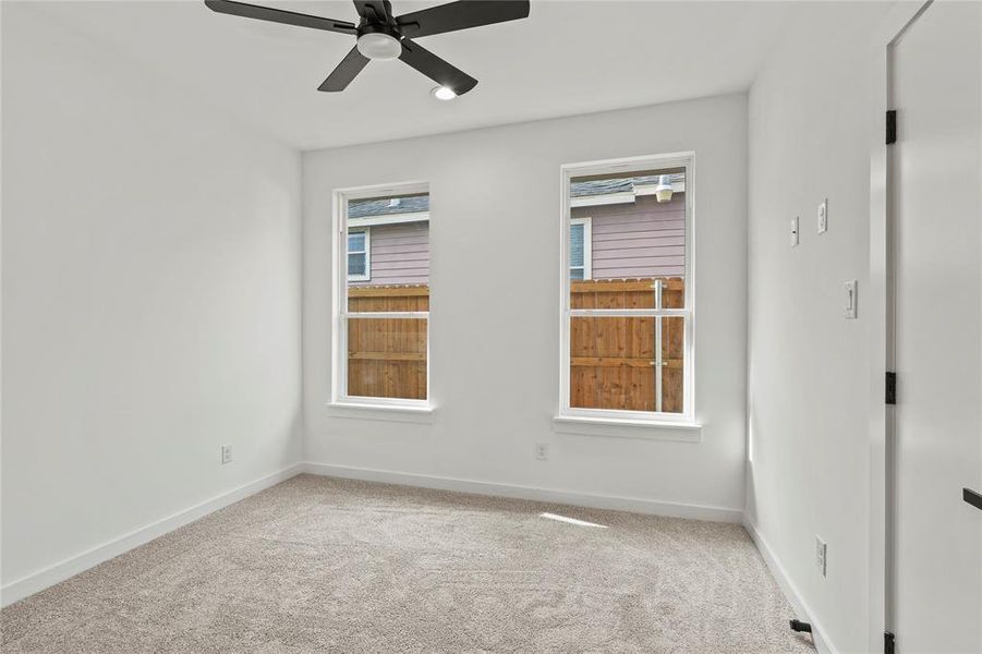 Empty room featuring carpet flooring and ceiling fan