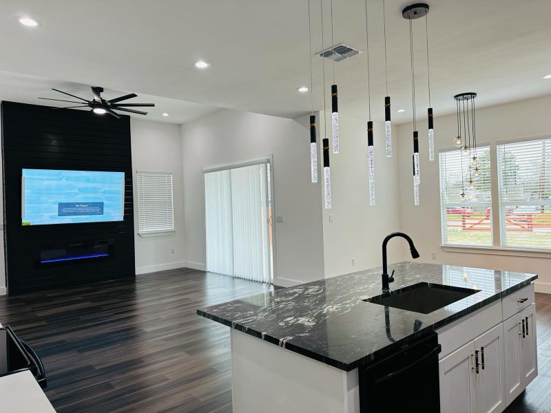 Kitchen with dark stone countertops, dark wood-style floors, a ceiling fan, white cabinets, and pendant lighting Kitchen with dark stone countertops, dark wood-style floors, a ceiling fan, white cabinets, and pendant lighting