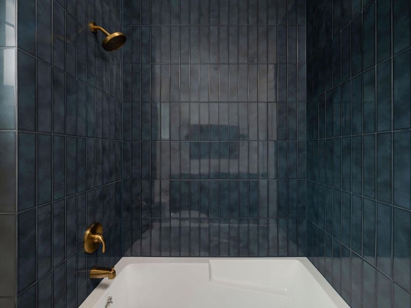 A deep-hued tiled shower and tub combination offers a clean, functional bathing space.