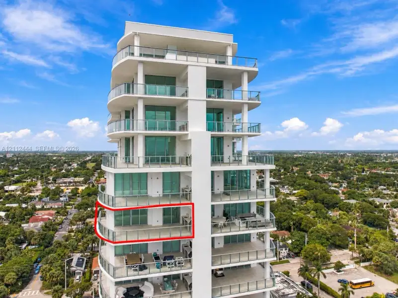 High-rise residential exterior featuring glass-railed private balconies, floor-to-ceiling windows, and integrated outdoor kitchen fixtures