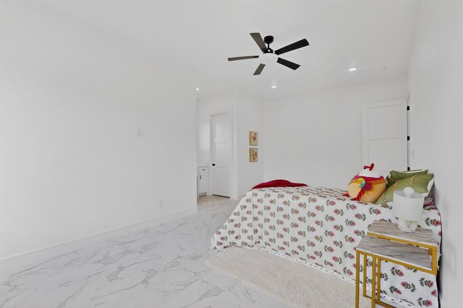 White-painted room featuring large format marble-look tile flooring and recessed lighting