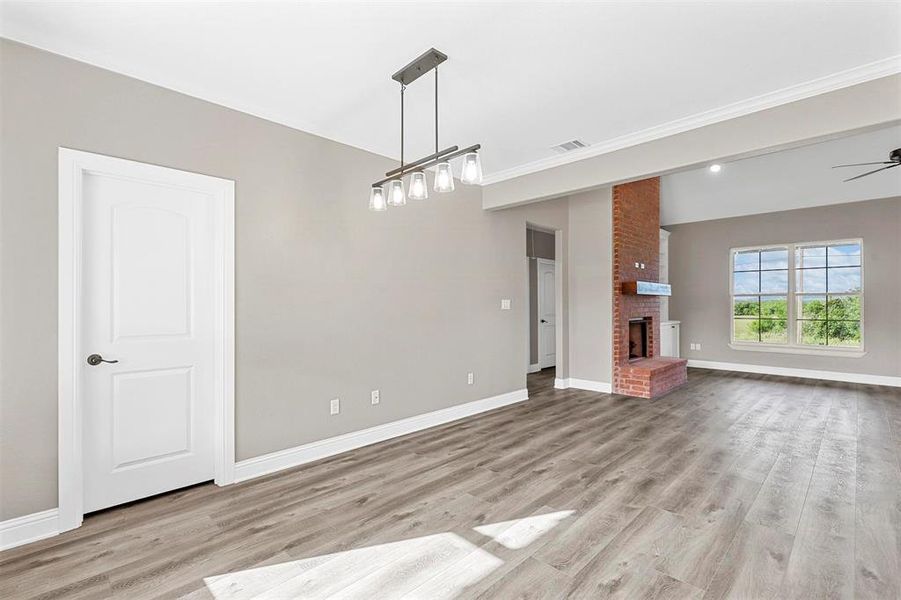 Unfurnished living room with a fireplace, light hardwood / wood-style floors, and ceiling fan